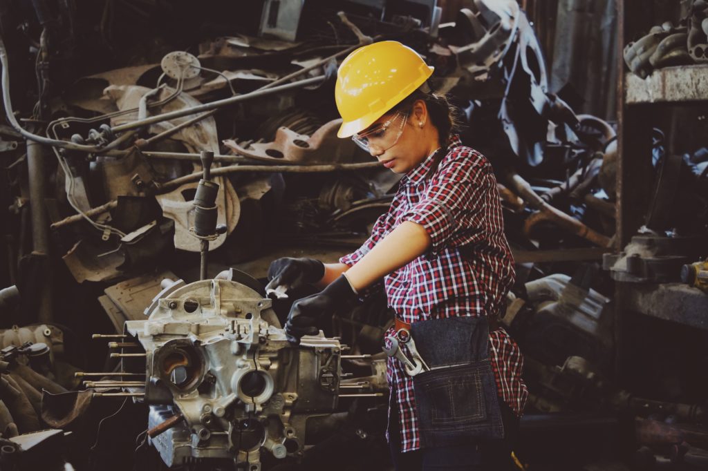 A female mechanical engineer works on a piece of machinery