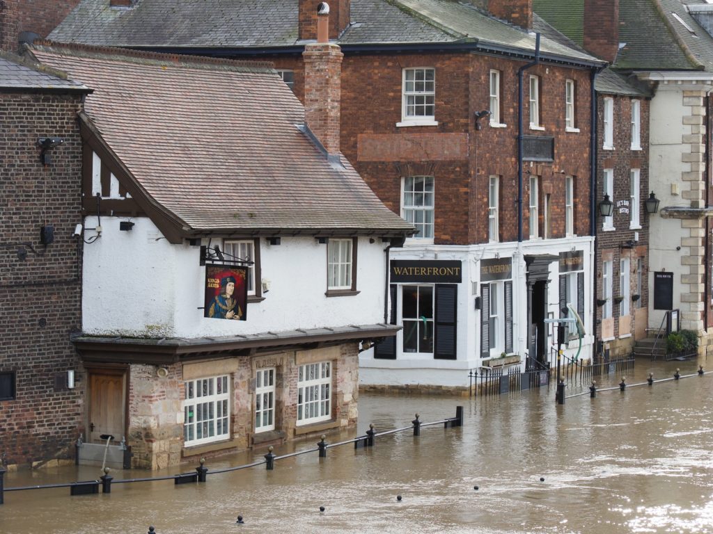 A pub called the Waterfront on a street in York partially submerged under flood water. 